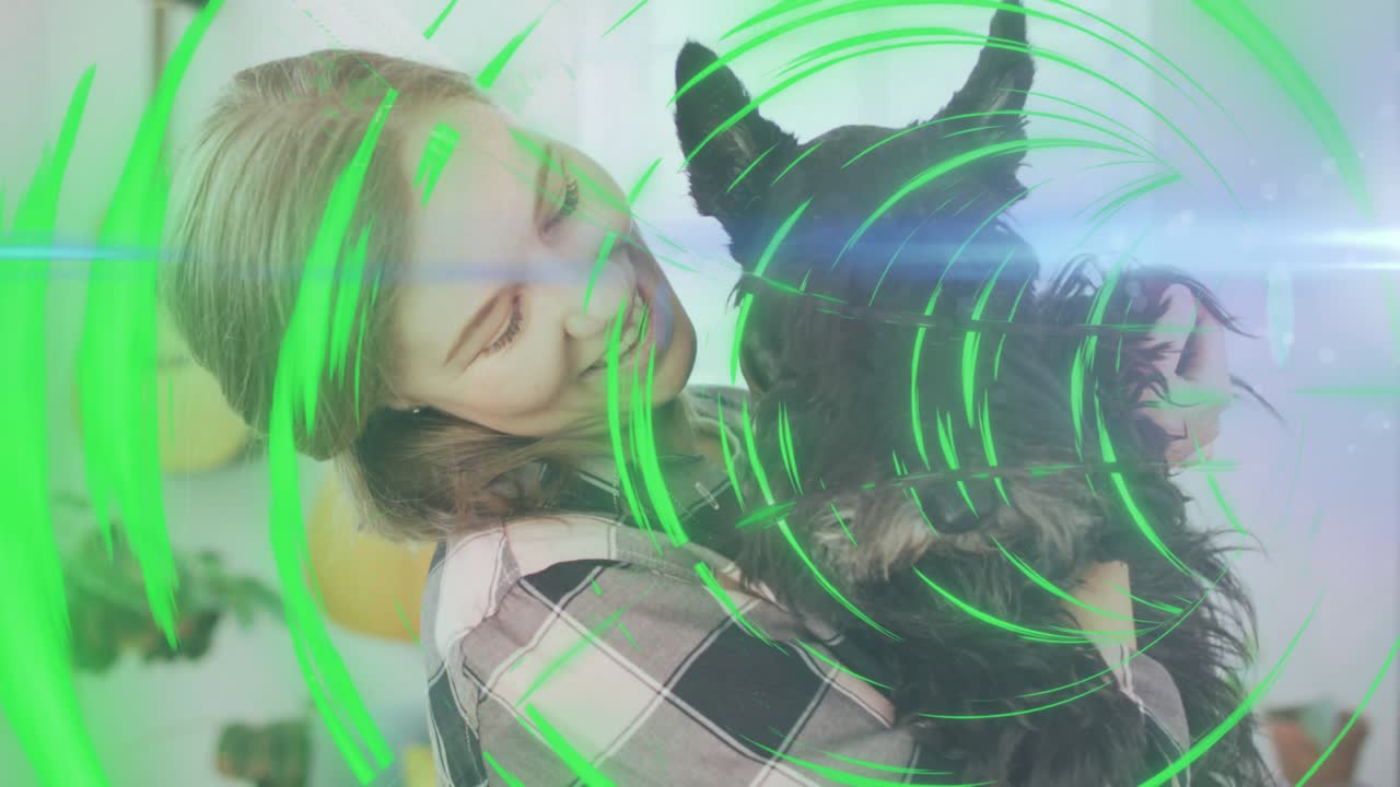 Woman lifting, cradling dog in home with animated rings sweeping across frame signaling pet care