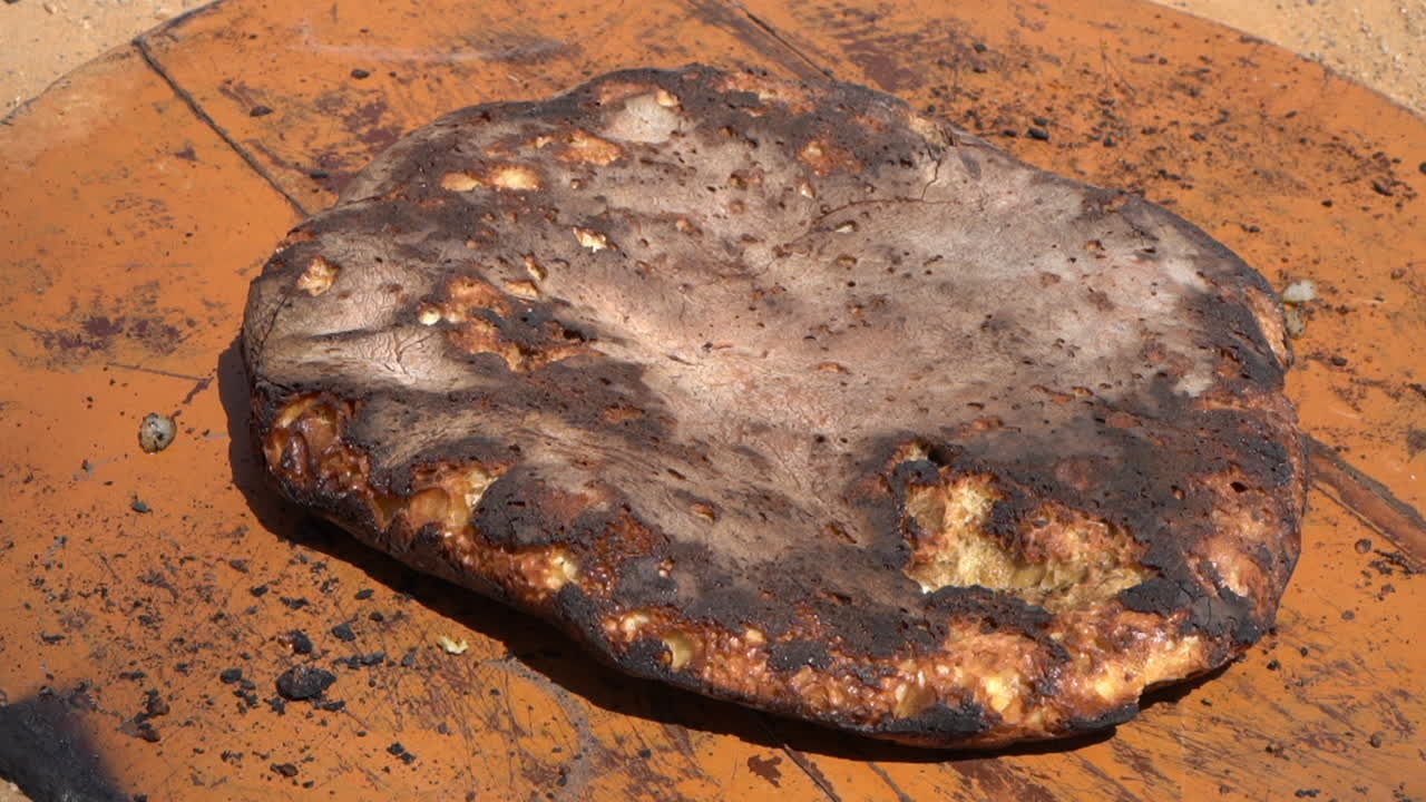 Indulge in the mouthwatering flavors of Tafarnoute, a traditional Moroccan Sahara bread, also known as the 'desert pizza