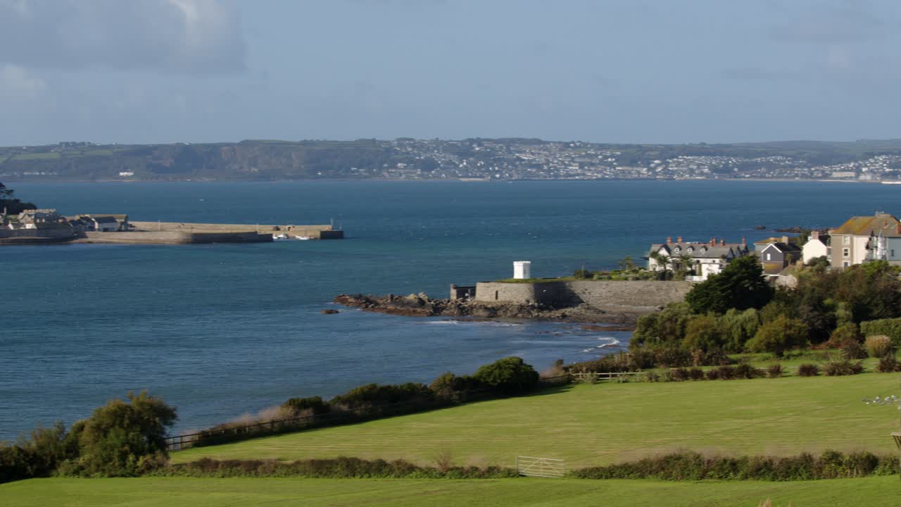 wide panning shot of St Michael's mount with the village of Marazion right of frame