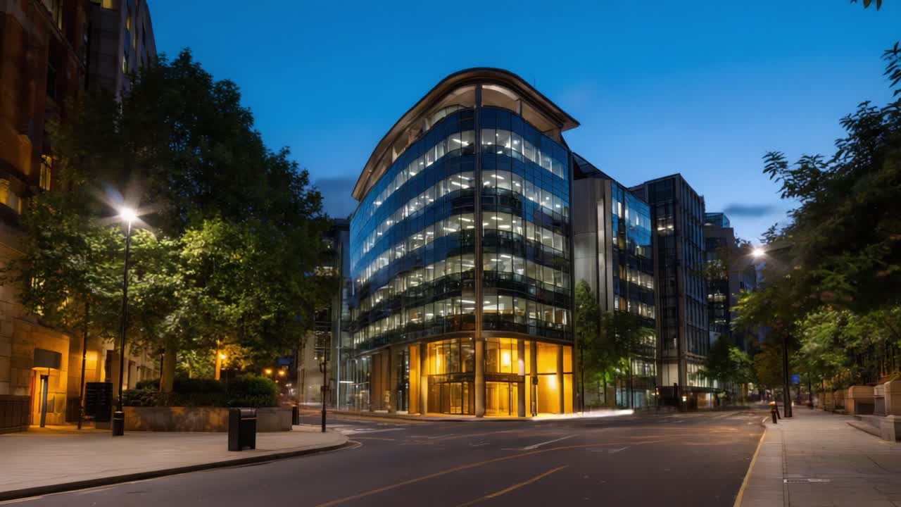 Arquitectura urbana moderna a la luz del atardecer: una vista cautivadora de un edificio de cristal enmarcado por árboles y farolas con el cielo crepuscular de fondo