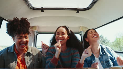 music, road trip and women friends hug in a van