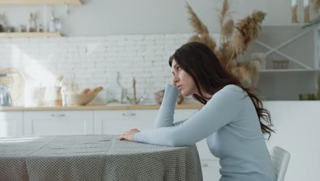 woman sitting alone in kitchen