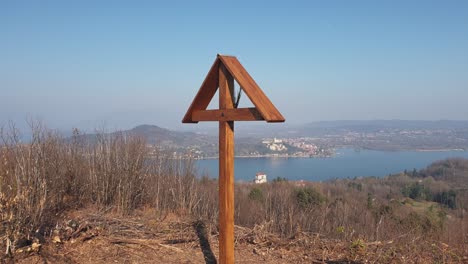 wooden cross on mountain motta grande at arona and maggiore lake in background