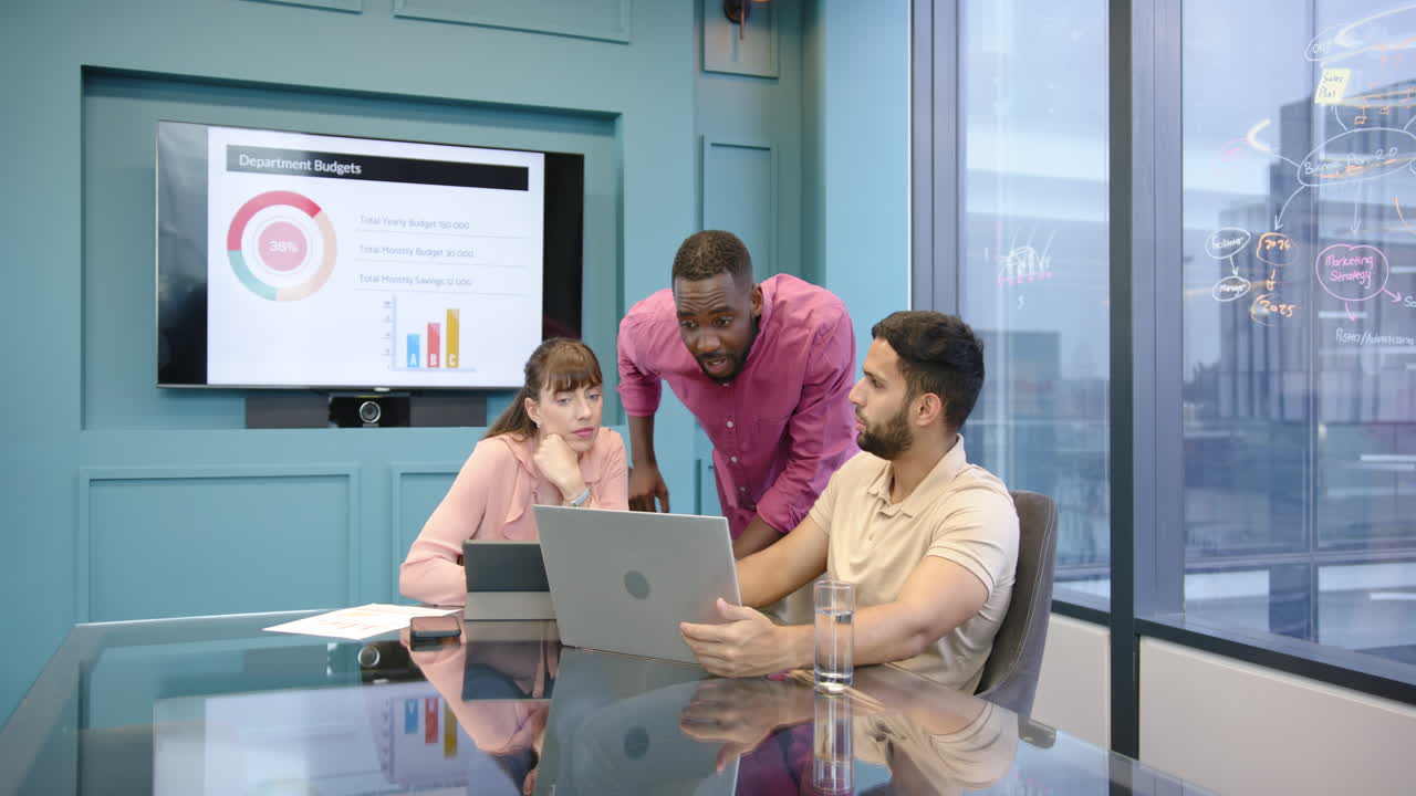 Business team discussing project, using laptop and presentation screen in office