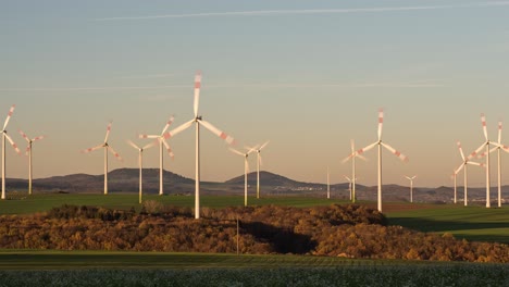 windturbines at wind power station during sunset in dungenheim, eifel, germany