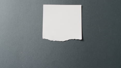 video de primer plano de un pedazo de papel blanco roto sobre un fondo negro