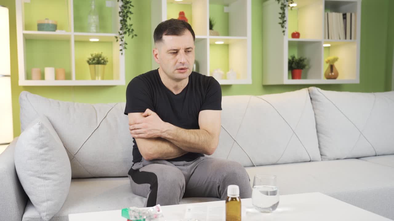 el hombre enfermo con neumonía tiene frío en casa y tiembla.