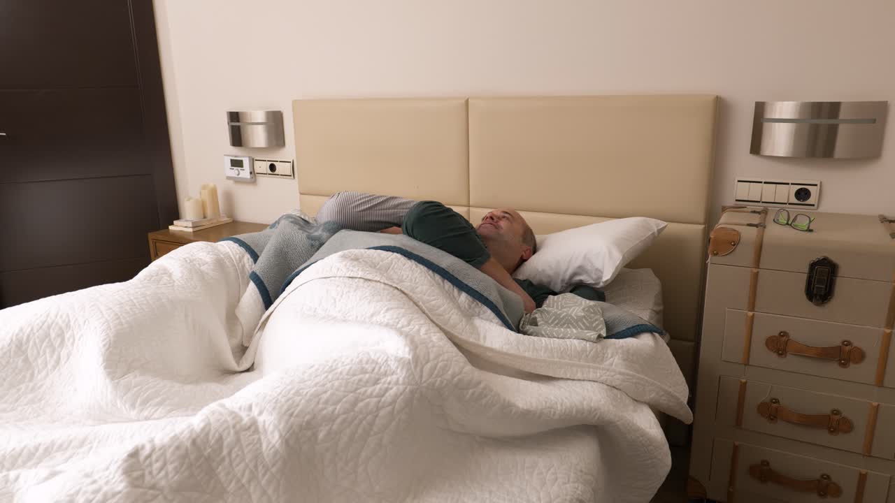 Gay mature couple of men awaking in bed at home