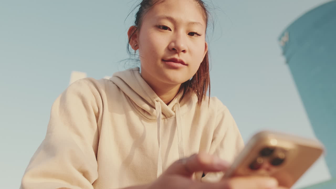 屋外で携帯電話を使用する若い女性