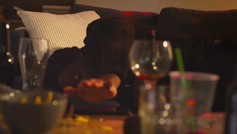 hombre despertando en el sofá después de beber alcohol en la fiesta de la casa sufriendo de resaca contestando el teléfono móvil 1