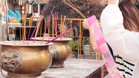 woman offering incense at hong kong temple