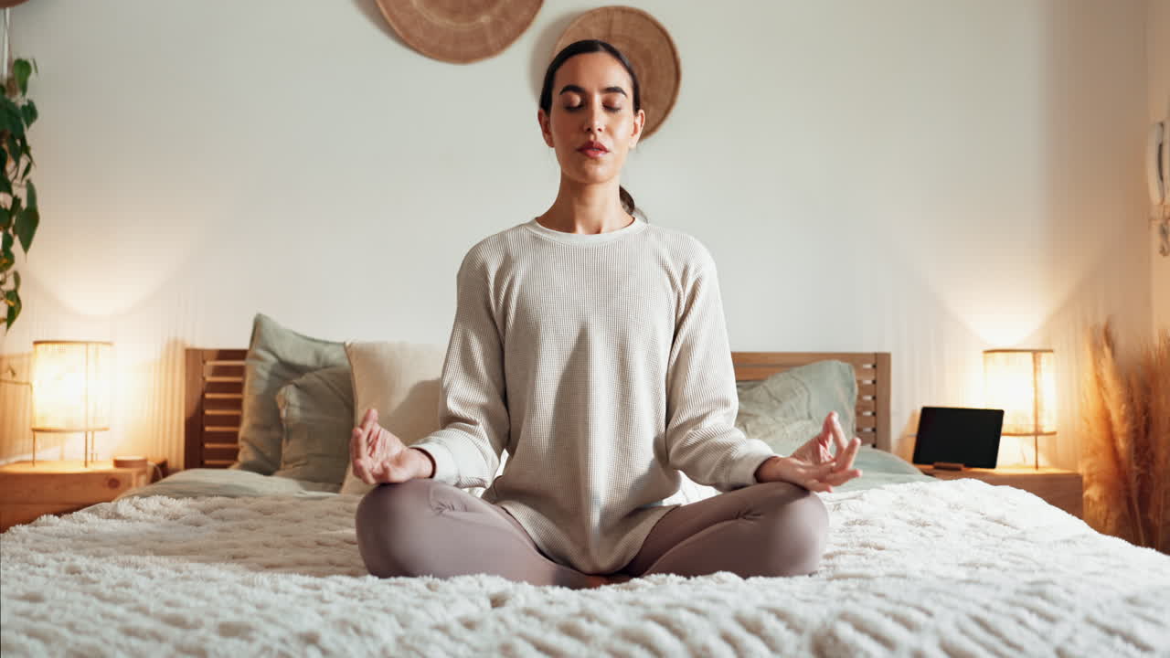 una mujer meditando en su dormitorio.