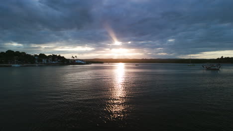 aerial view low over the de contas river, dramatic sunset in itacare, brazil