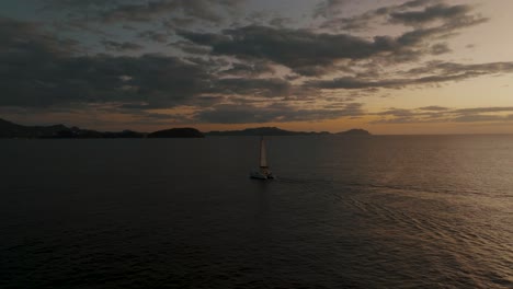 Sailboat-On-The-Ocean-At-Sunset-In-Guanacaste,-Costa-Rica---aerial-drone-shot