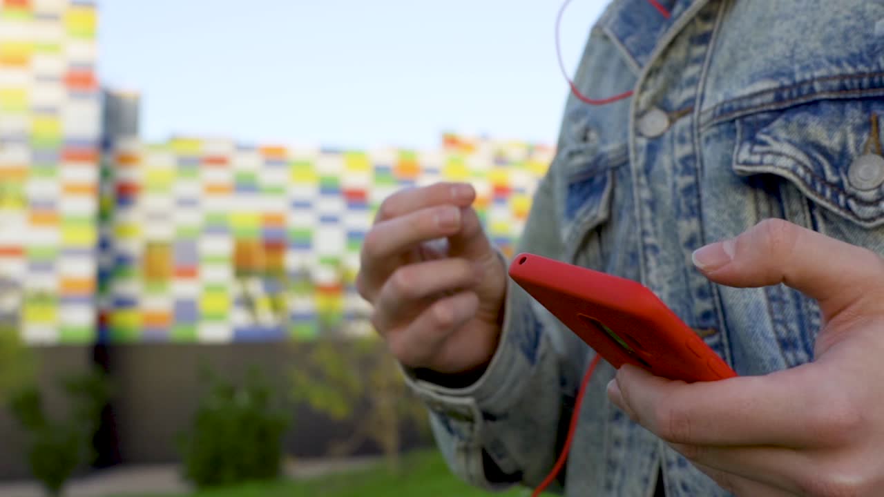 reproducir música en el teléfono celular rojo y chasquear los dedos al ritmo