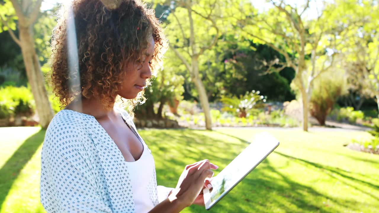 Donna che utilizza compressa digitale nel parco