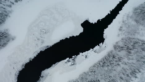 aerial view looking down rising above cold winter woodland lake in norbotten swedish landscape