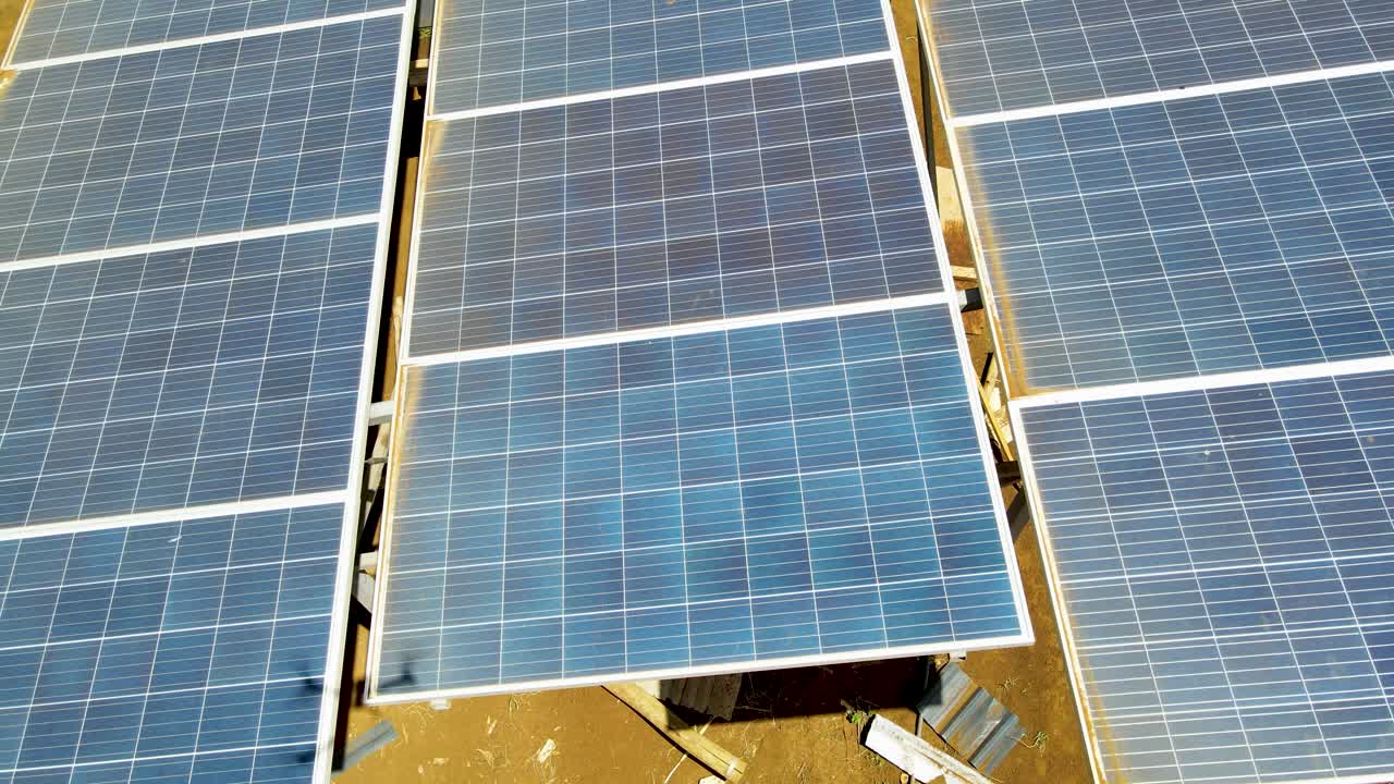 vista aérea de drones en grandes paneles solares en una granja solar al atardecer brillante