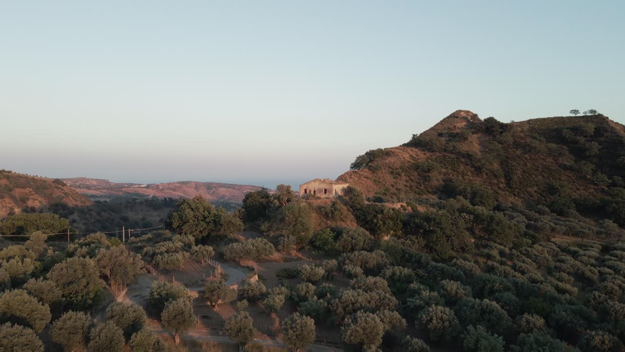 las ruinas de una antigua villa de granja se encuentran en la cima de una montaña con vistas al mar jónico en el sur de italia.