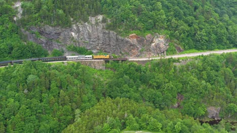 drone flying backwards over beginning of train in mountain of new hampshire