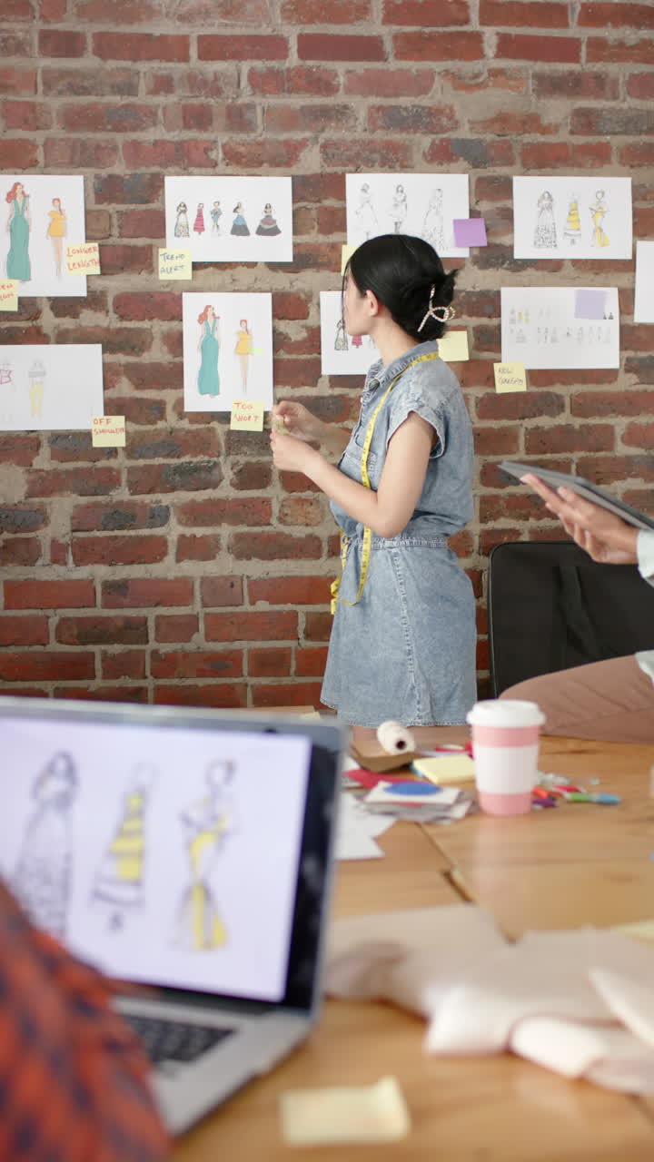 Vertical video of busy diverse business people using tablet and discussing projects