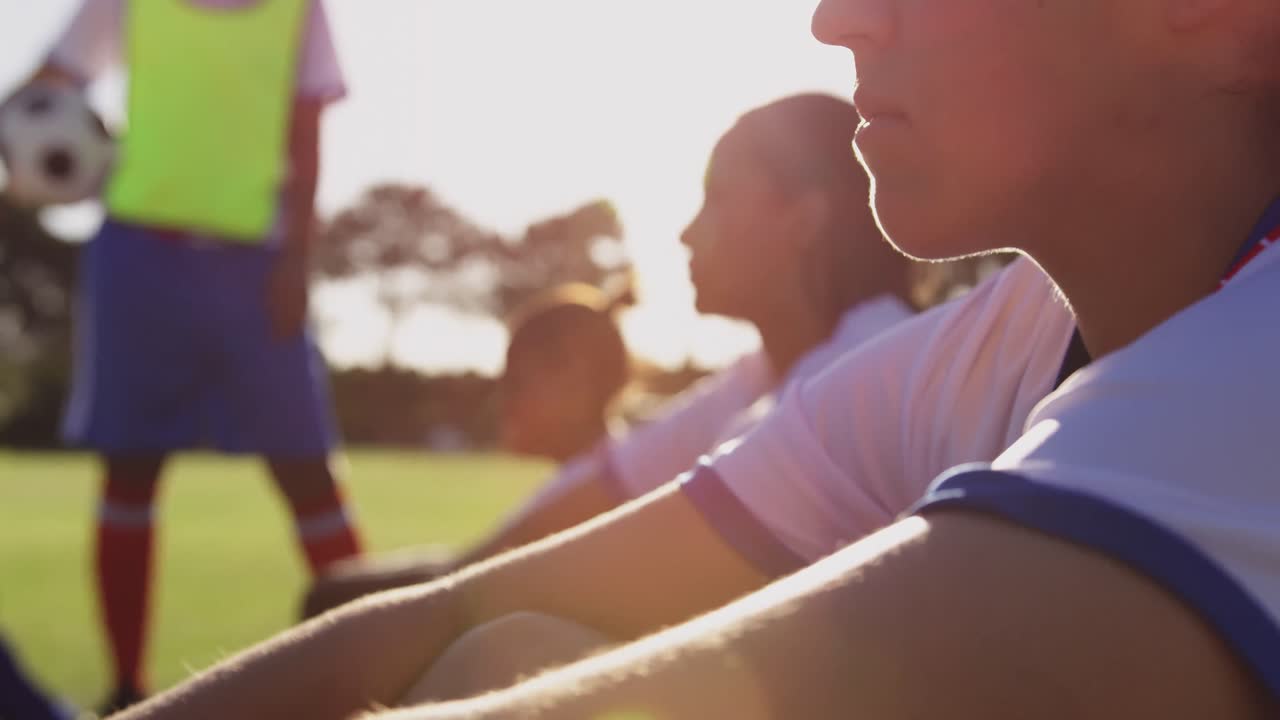 여자 축구 선수 가 축구장 에서 팀 동료 들  ⁇  에 바닥 에 앉아 있다. 4k