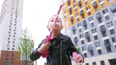 girl blowing bubbles in front of buildings