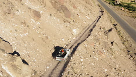 aerial footage of a car driving on a mountain road down to the highway in bishop, ca