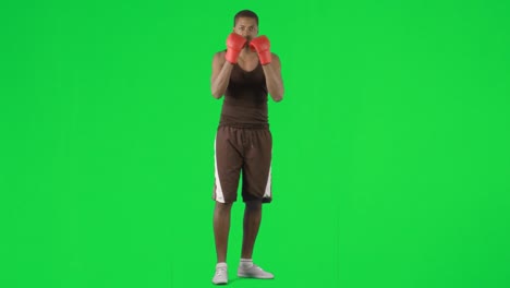 hombre afroamericano boxeando contra imágenes de pantalla verde