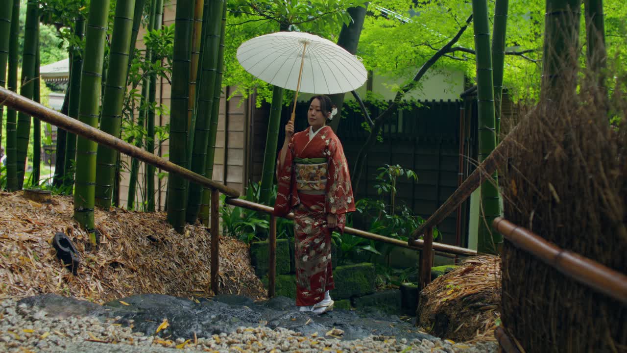 Japanese Woman in Kimono Walking Through a Bamboo Forest in the Rain