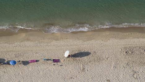man walks across empty mediterranean beach seen from above 4k
