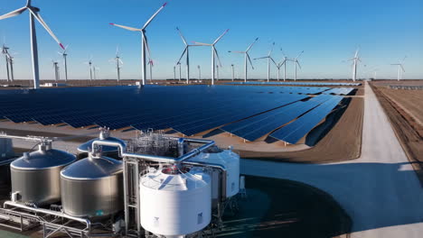 vast renewable energy facility with solar panels, wind turbines, and storage tanks