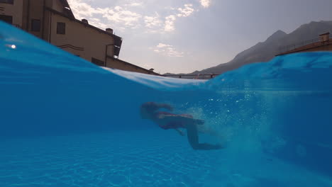 woman diving into a mountain view swimming pool