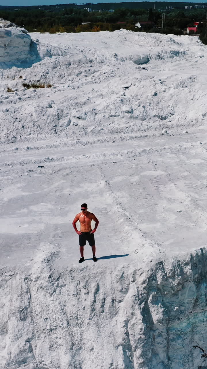 Professional bodybuilder posing outdoors. Concept of beautiful healthy body. Aerial view Vertical video