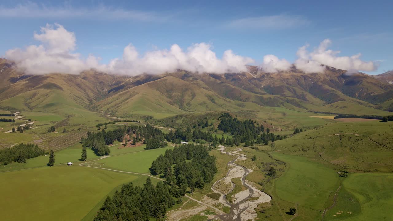imágenes aéreas de un río sinuoso procedente de una cordillera en el campo de nueva zelanda