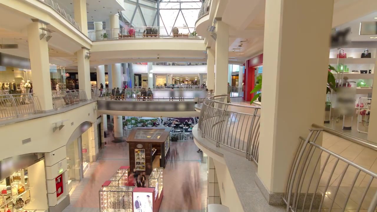 Muchas tiendas en grandes almacenes de varios niveles o centro comercial, timelapse hyperlapse. Vista aérea desde arriba. Clientes caminando