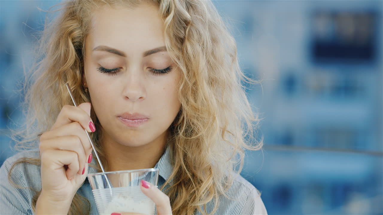 카메라에 미소 카페에서 아이스크림을 먹고 매력적인 젊은 여자