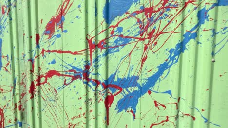 red and blue paint splatters on green surface