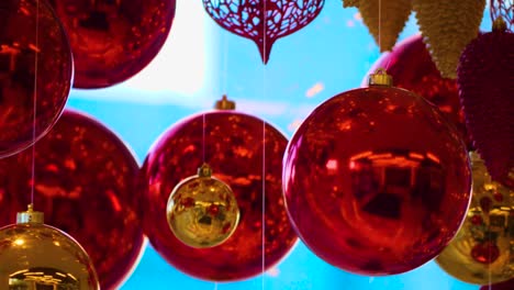 christmas and new year decoration. christmas big red balls on  background of luminous lanterns and gold garlands. holiday background. blinking garland. red baubles with lights twinkling close up.