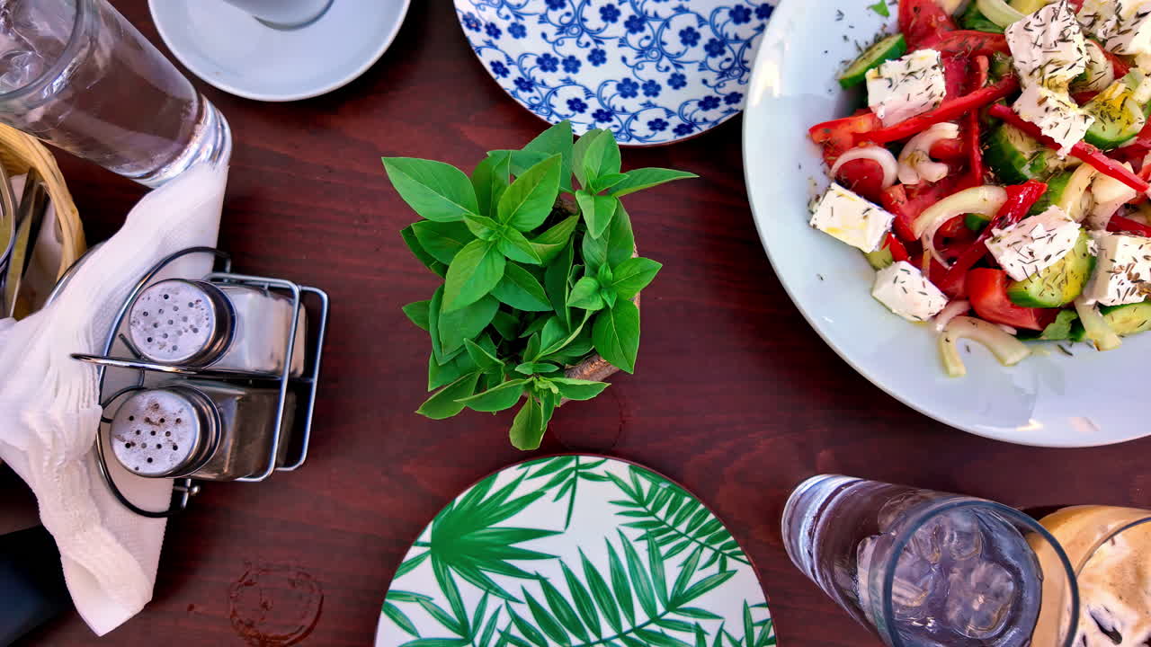 Traditional Greek Horiatiki Salad Served Over Outdoor Restaurant In Sivas, Crete, Greece - Top View