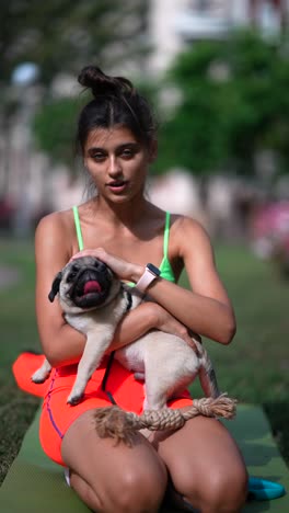 woman and pug dog in park