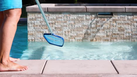 4k looping seamless cinemagraph of woman skimming swimming pool water