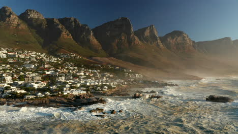 las olas rompen en la escarpada costa de la playa de camps bay en ciudad del cabo, sudáfrica