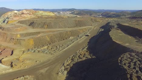 Heavy-machinery-working-in-te-riotinto-open-pit-copper-mine-aerial-shot