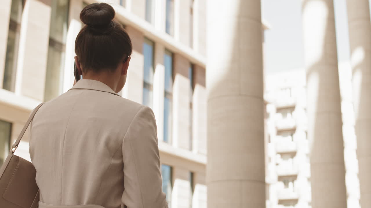 Rear-View of Businesswoman Walking in City Downtown