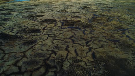 Grietas-Negras-Oscuras-De-Residuos-De-Asfalto-De-Petróleo-Tóxico-En-El-Lago-Del-Pozo-De-Basura,-Plataforma-Rodante-Aérea