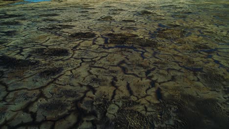 grietas negras oscuras de desechos tóxicos de petróleo y asfalto en el lago de basureros, carretilla aérea