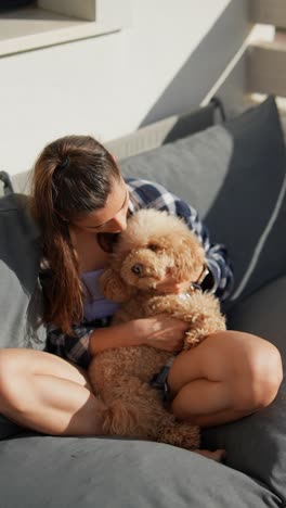 teenager cuddling her dog on a patio couch