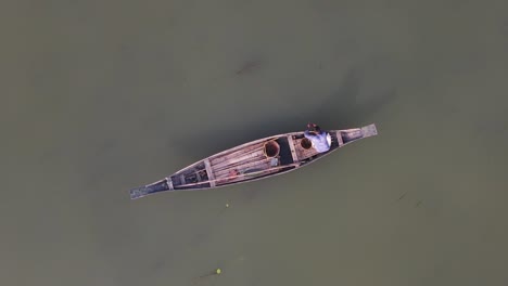 small traditional asian boat with fisherman in bangladesh, aerial overhead