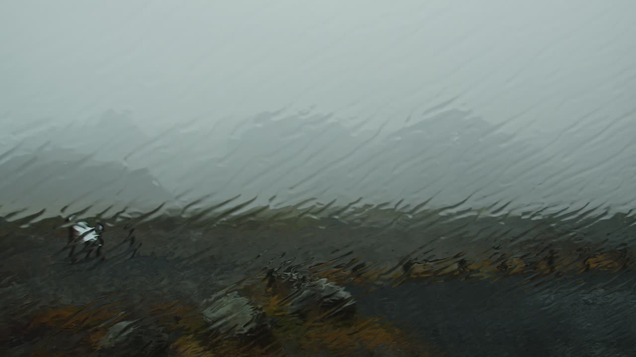 Wide view of Icelandic landscape through a car window in a heavy storm